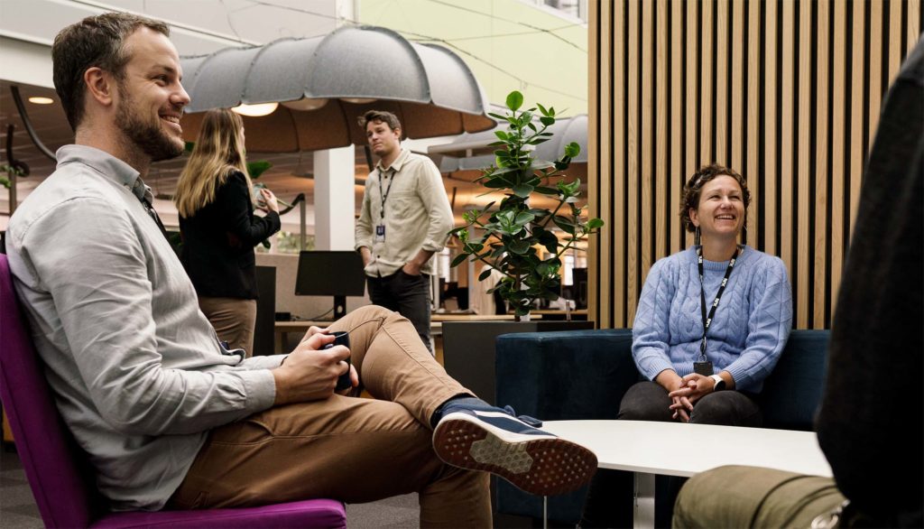 NRK-ansatte i prat i hyggelig arbeidsmiljø.