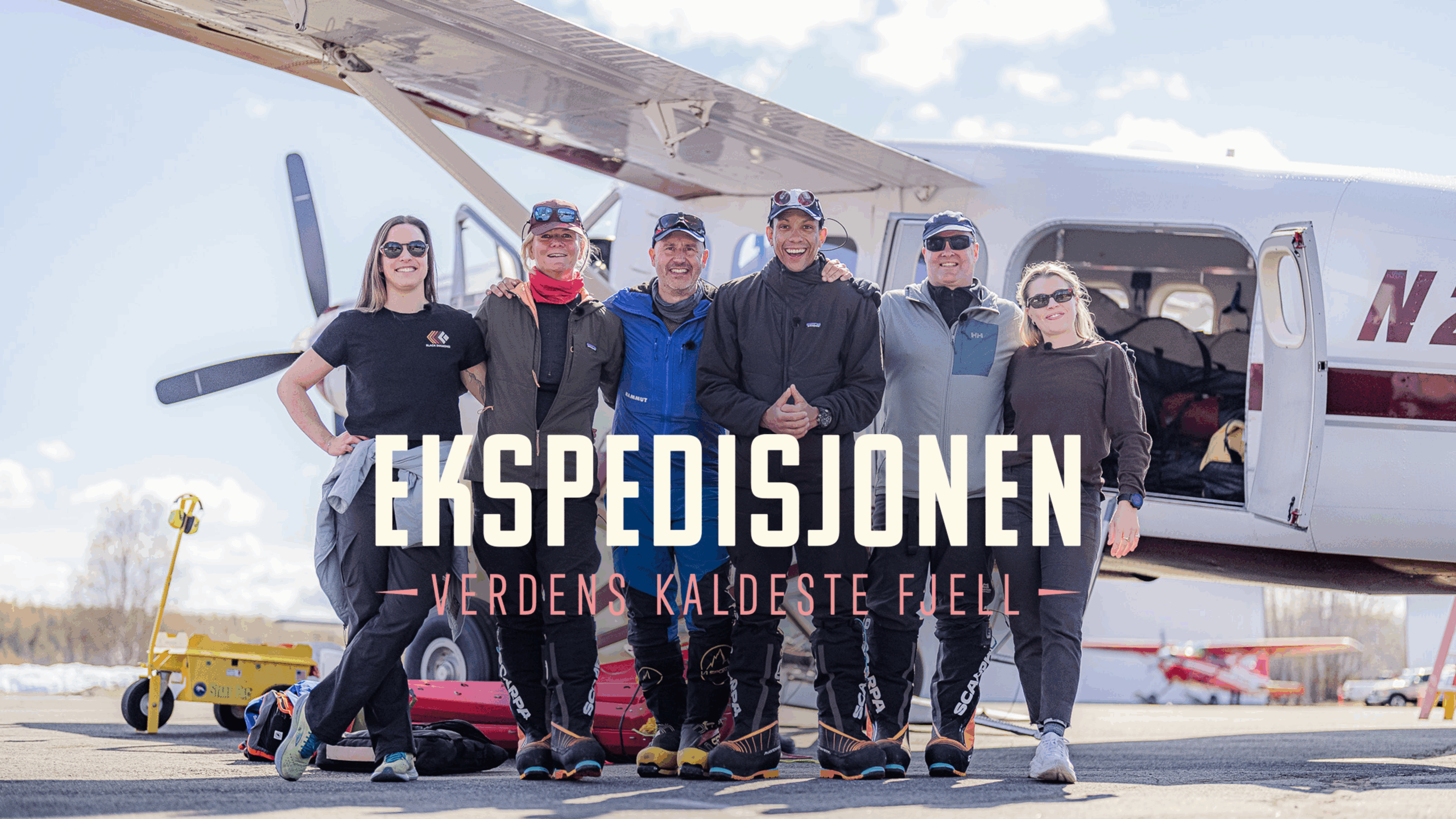 Deltakerne i Ekspedisjonen står foran helikopteret.